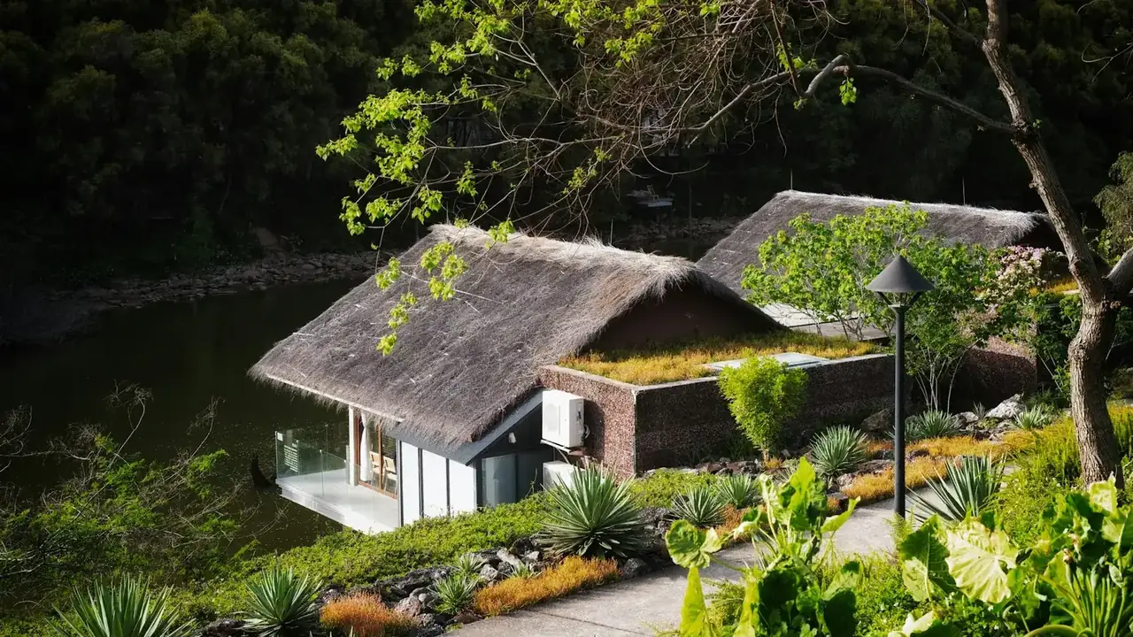 Bangalôs com telhado de palha em meio a um jardim tropical